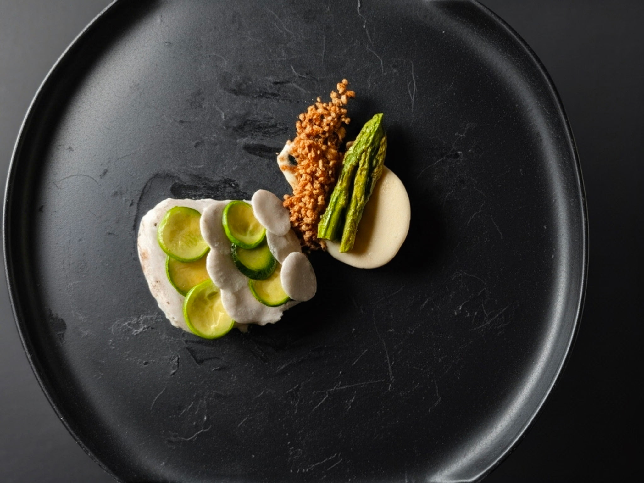 Asparagus and cream on dark plate