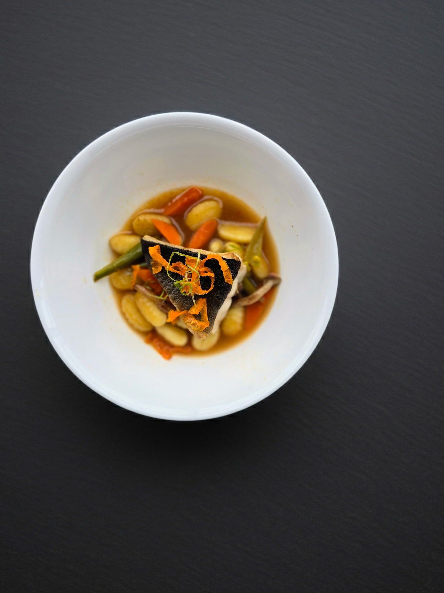 Fish with gnocchi in savory broth
